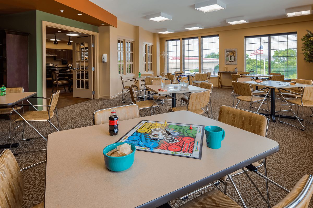 A cozy cafe with tables and chairs, featuring a board game setup on one of the tables.