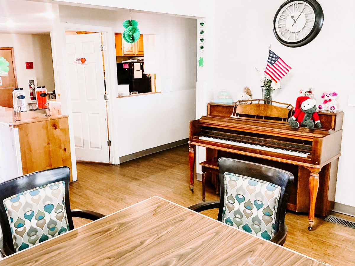 A cozy office space featuring a piano, desk, and decor.
