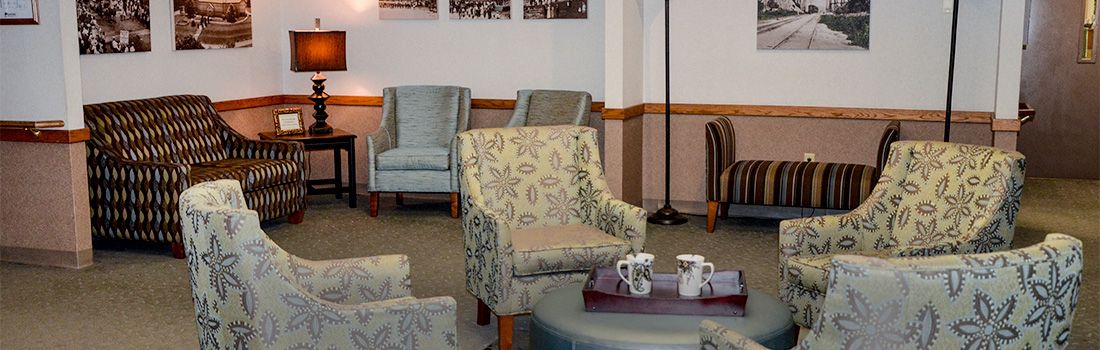 A cozy waiting area featuring patterned chairs and a table with coffee mugs.