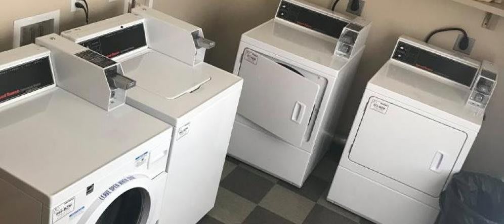 A row of laundry appliances in a laundromat.