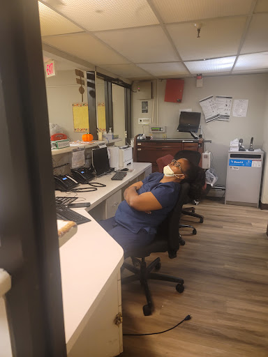 An individual resting at their desk in an office setting.
