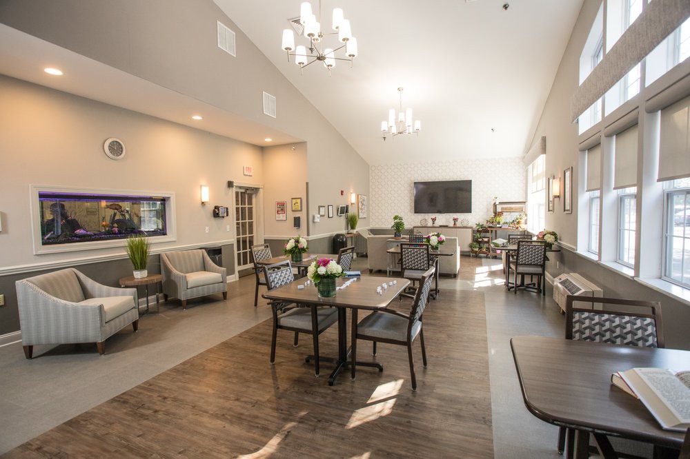 A spacious and modern dining room interior with ample seating and elegant chandeliers.