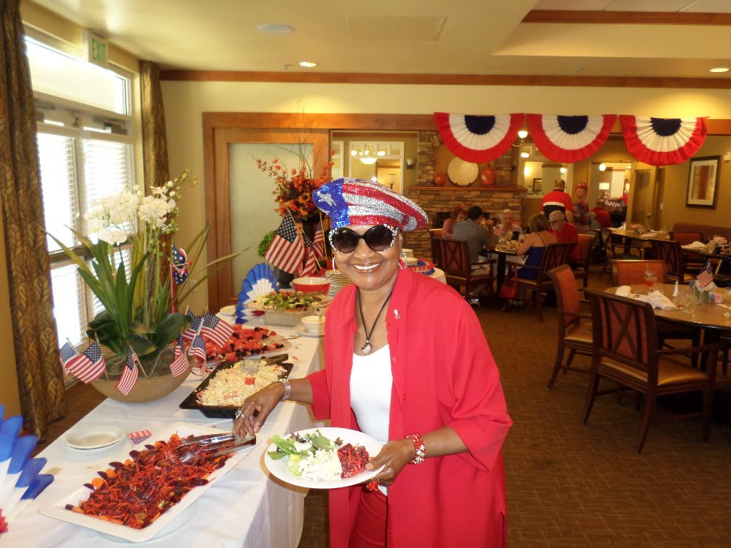 A person enjoying a patriotic themed celebration indoors with a buffet of food and festive decorations.