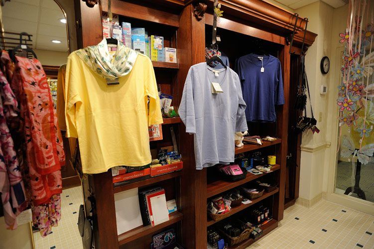 A retail store display featuring a variety of shirts and other items on wooden shelves.