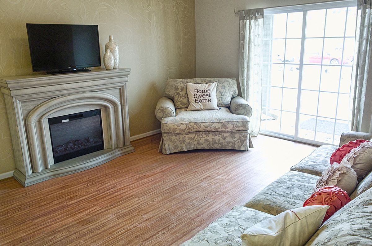 A cozy living room with a fireplace, armchair, and sliding door.