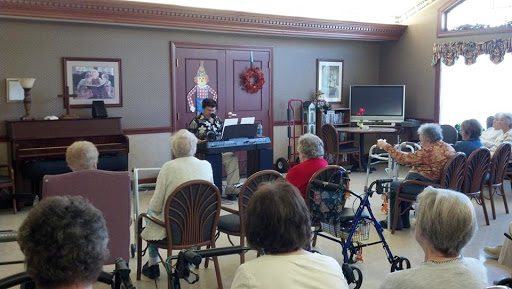 A young performer entertains a group of seniors at a community center.