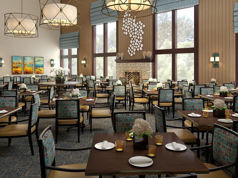 A spacious and elegantly decorated dining room with large windows and ambient lighting.