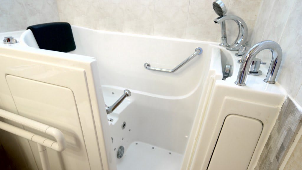 An accessible walk-in bathtub with safety handrails and a door for easy entry.