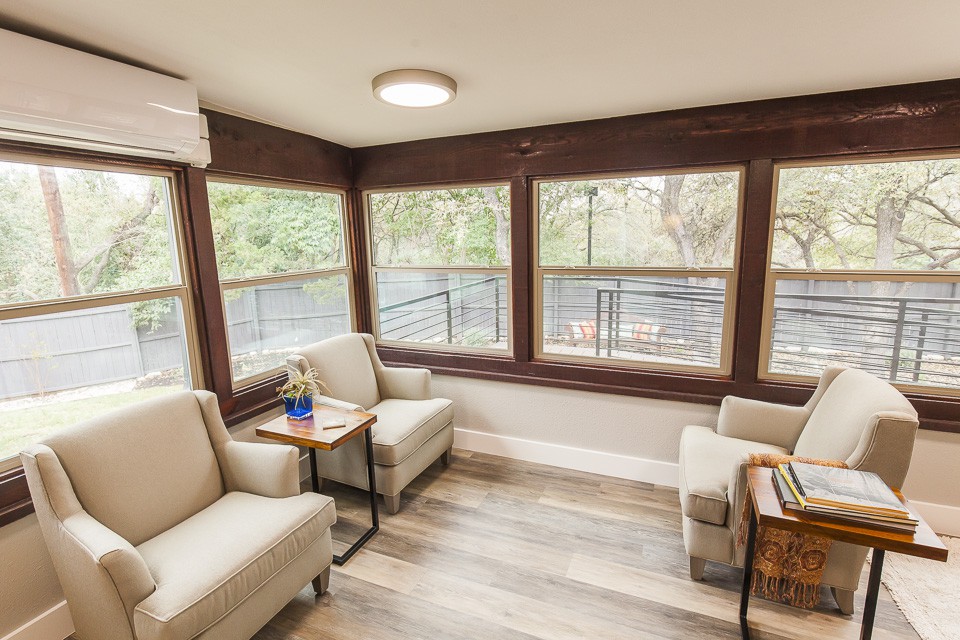 A cozy living room with large windows offering natural light and a modern design.
