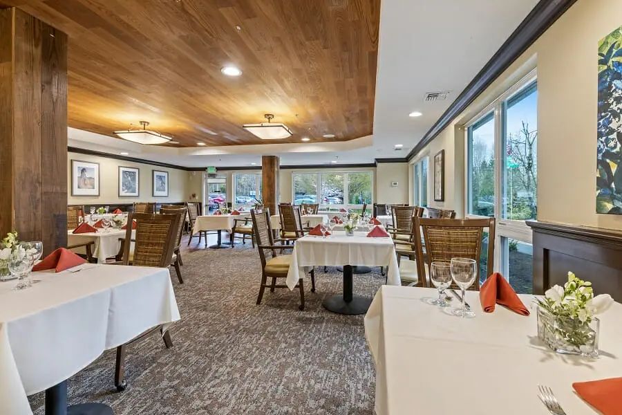 A well-lit restaurant dining area with neatly arranged tables and chairs, showcasing elegant interior design.