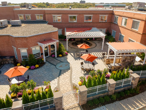 A serene outdoor courtyard featuring vibrant gardens and comfortable seating areas.