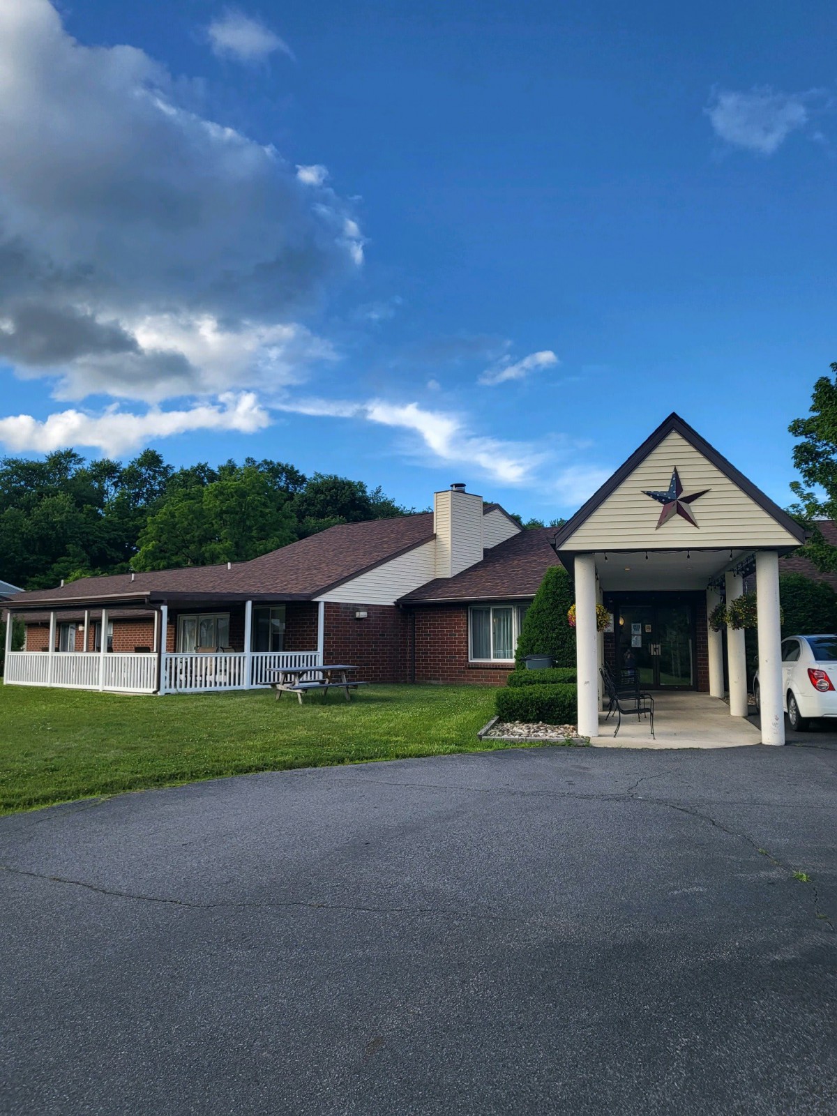 A house with a covered driveway and veranda on a clear day.