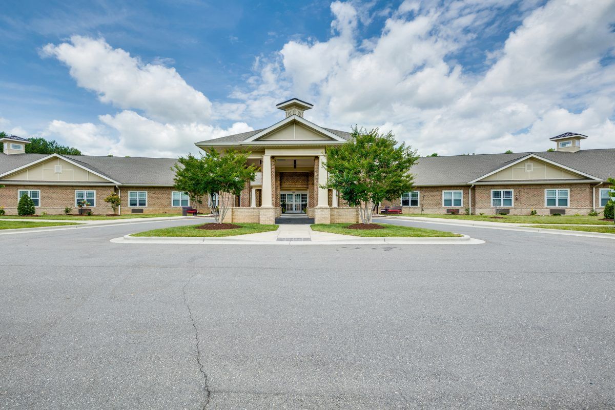 A symmetrical building with a prominent entrance under a partly cloudy sky.