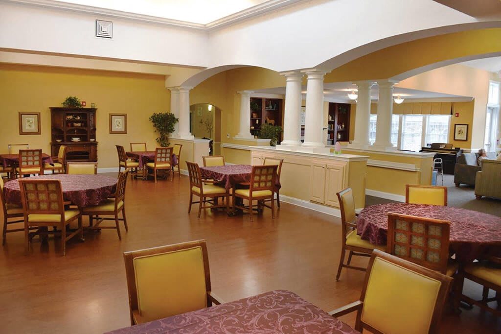 A well-lit dining area with several tables and chairs arranged neatly.