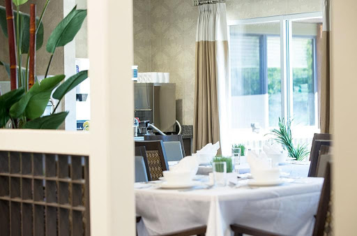 A beautifully arranged dining room featuring a modern table setting and abundant natural light.