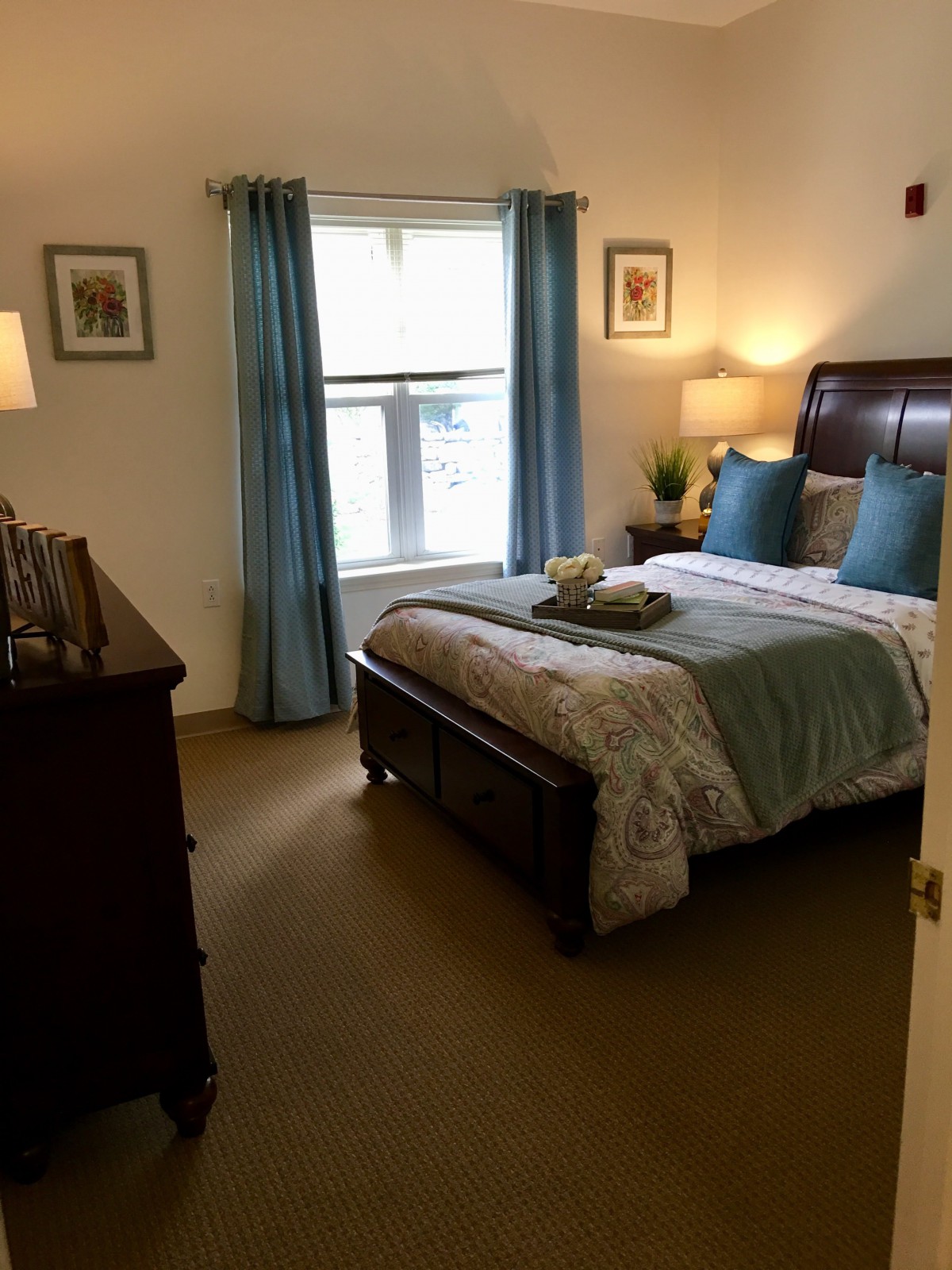 A cozy bedroom with a neatly made bed and blue accents.