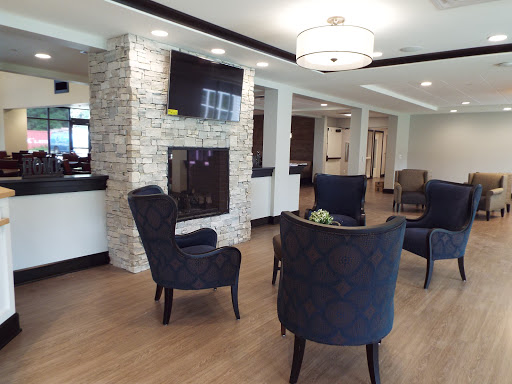 A modern lobby seating area featuring stylish chairs and a cozy fireplace.