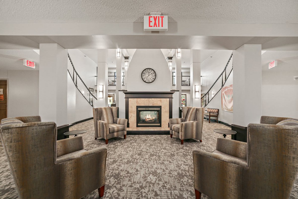 A modern lobby with comfortable seating and a central fireplace.
