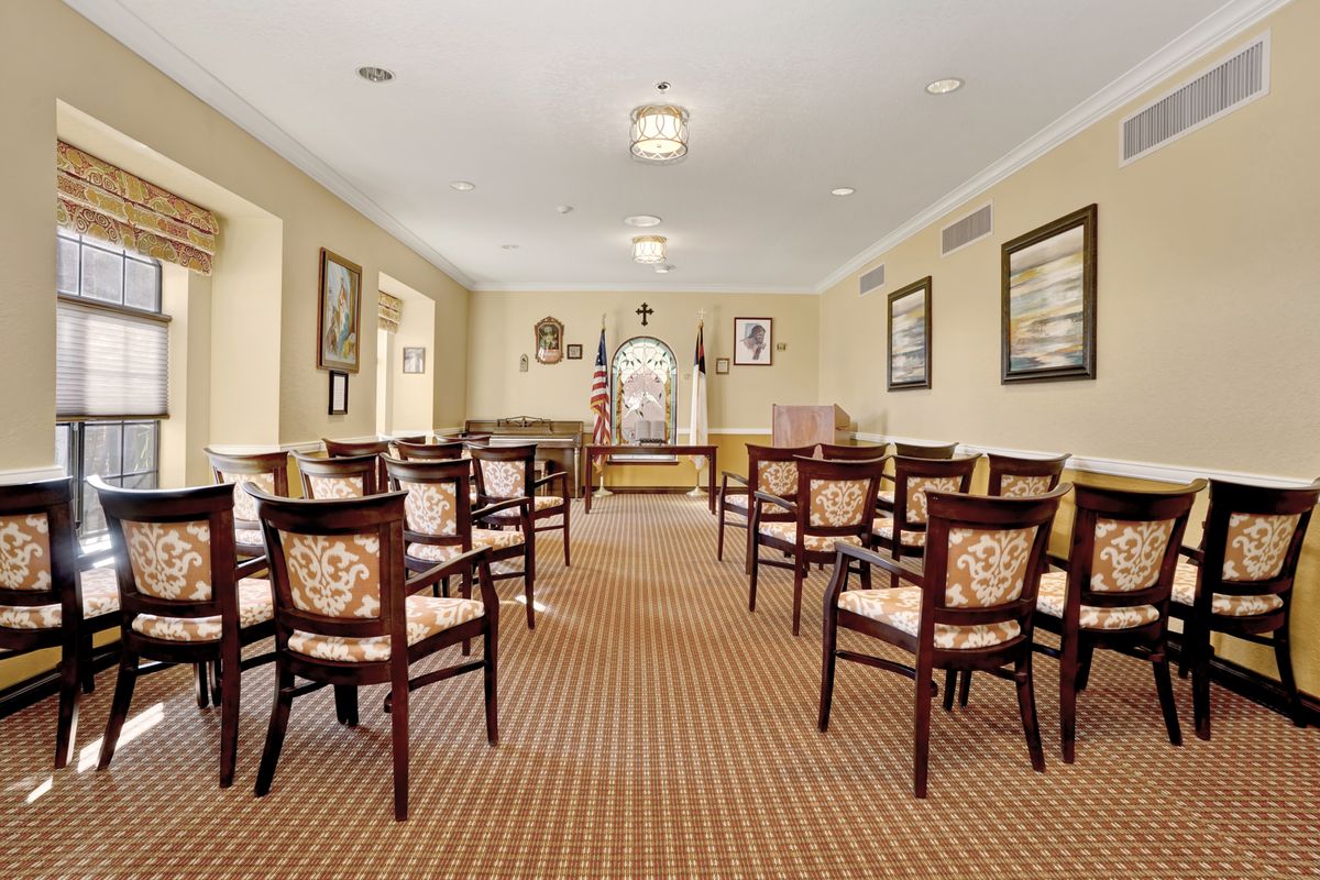 A neatly arranged meeting room with rows of chairs and carpeted flooring.