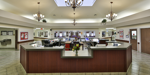 A modern office reception area featuring a clean and well-lit workspace with stylish furniture and decorative lighting.