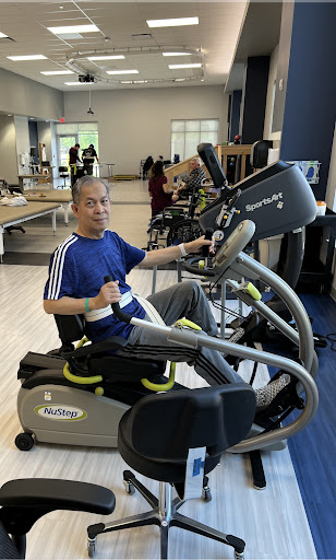 A person engaging in exercise on a specialized workout machine at the gym.