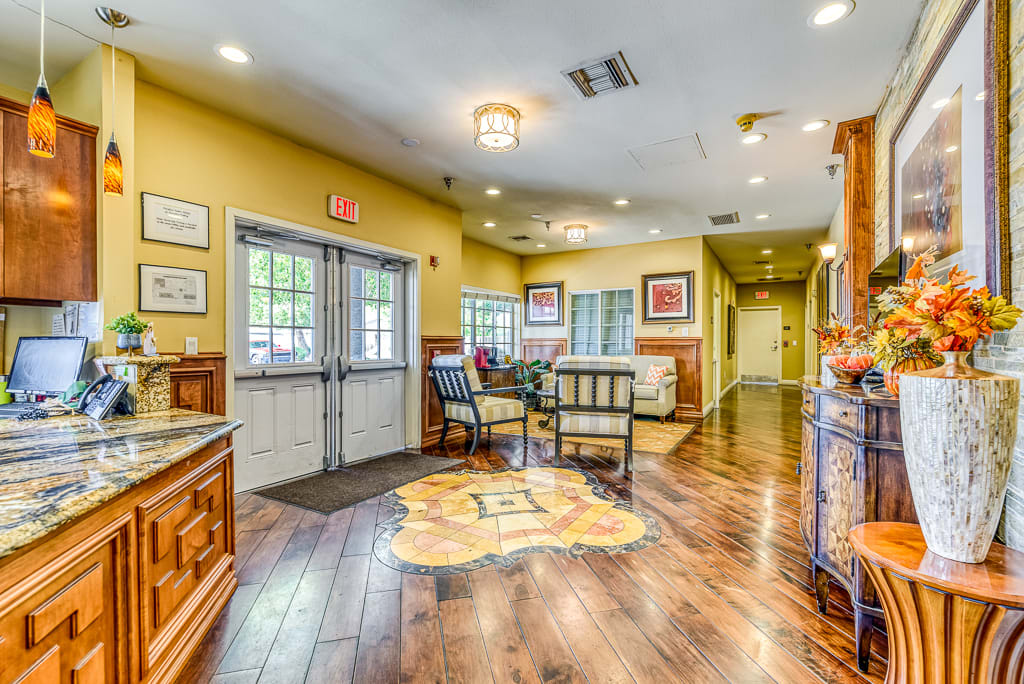 A warmly decorated lobby with comfortable seating and wooden flooring.