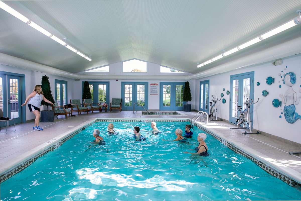 A group of people enjoying a swimming session in an indoor pool.