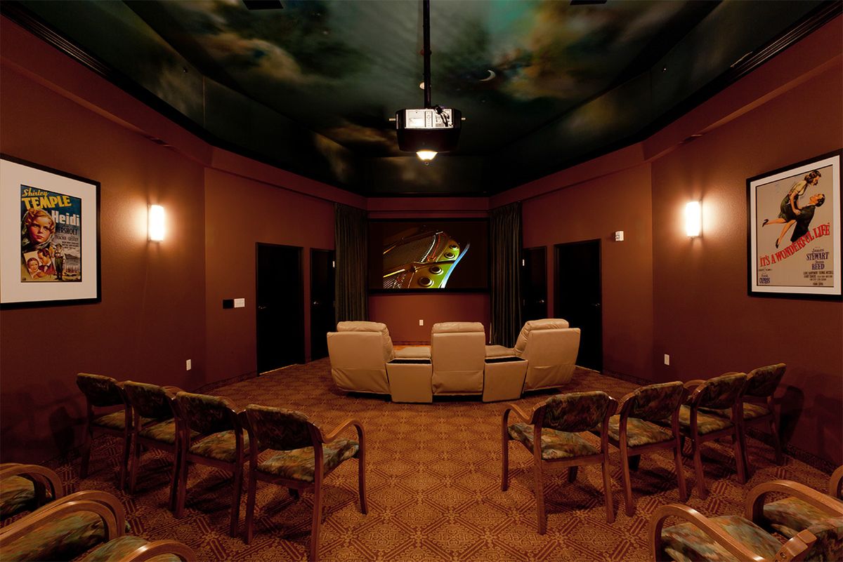 A cozy home theater setup with comfortable seating and a projector screen.
