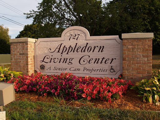 Entrance sign of the AppleDorn Living Center, showcasing a welcoming atmosphere with vibrant landscaping.