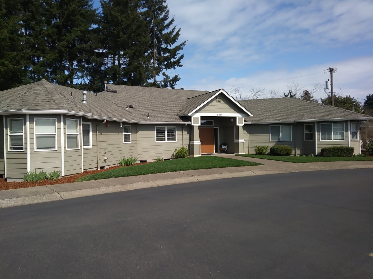 A suburban house with a well-maintained front yard under a clear sky.