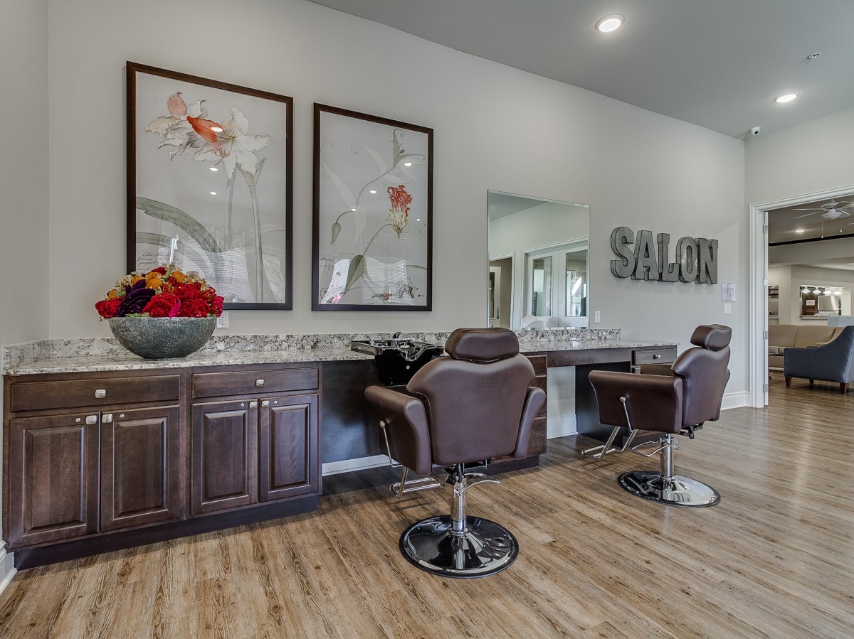 A modern salon interior featuring two styling chairs, mirrors, and vibrant artwork on the walls.