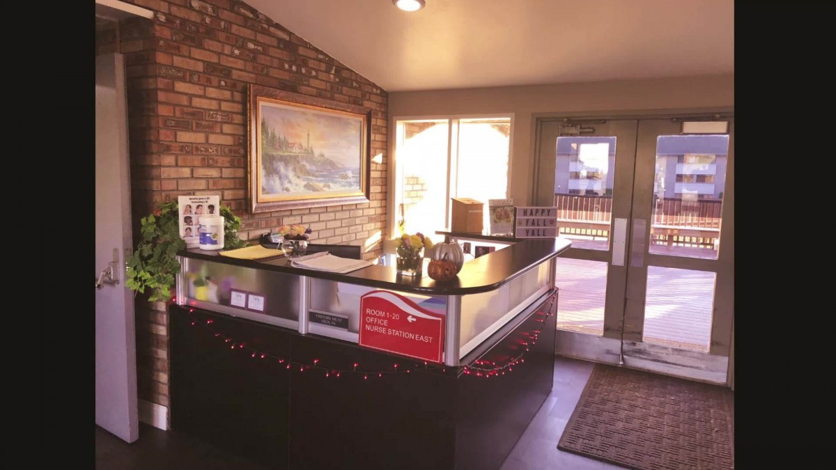 A modern reception desk in an office with brick walls and natural lighting.