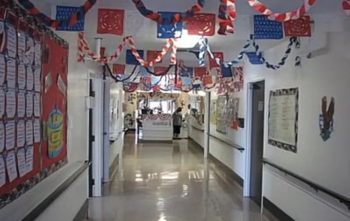 A decorated hospital hallway with patriotic red, white, and blue banners hanging from the ceiling.