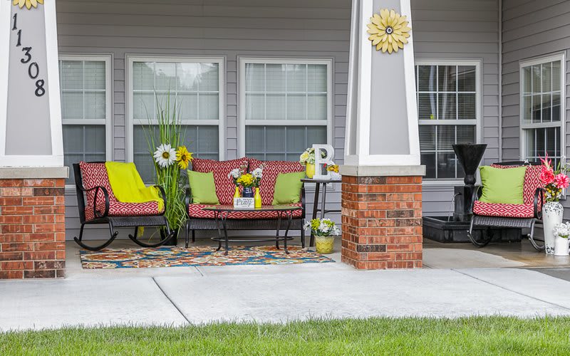 A cozy patio setup with colorful chairs and sunflower decorations.