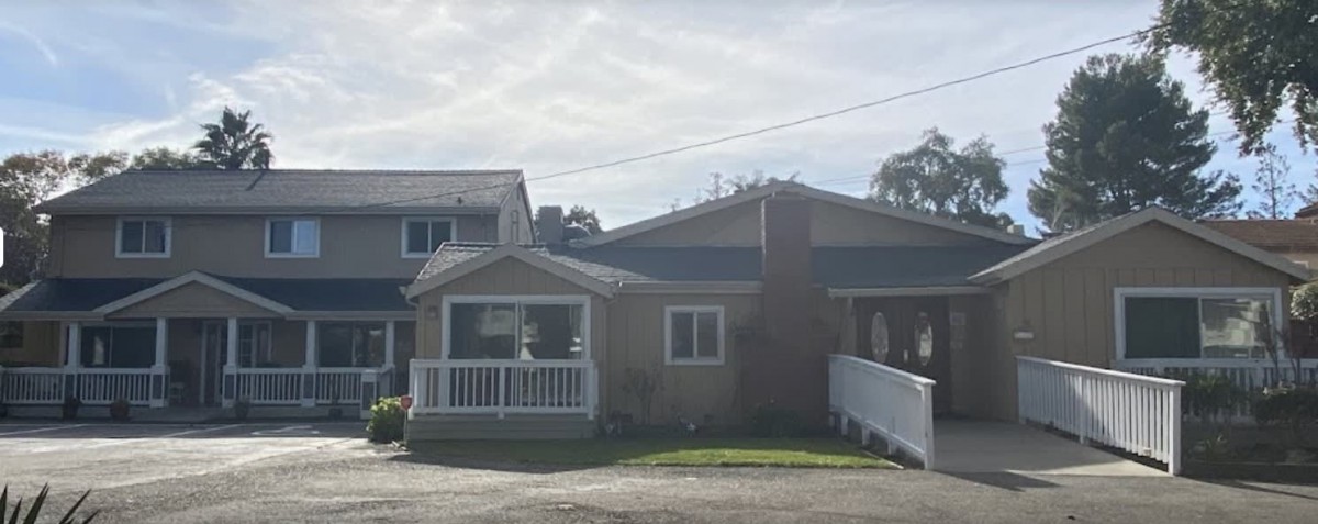 A suburban residential house with a small porch and a brick chimney.