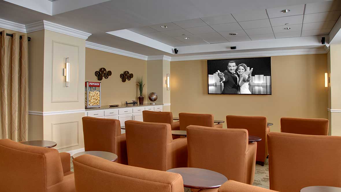 A cozy theater room with comfortable seating, featuring a large screen and a popcorn machine for an enjoyable viewing experience.