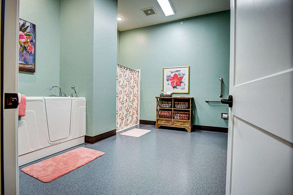 A bright and organized laundry room with mint green walls, featuring a washing machine and colorful artwork.