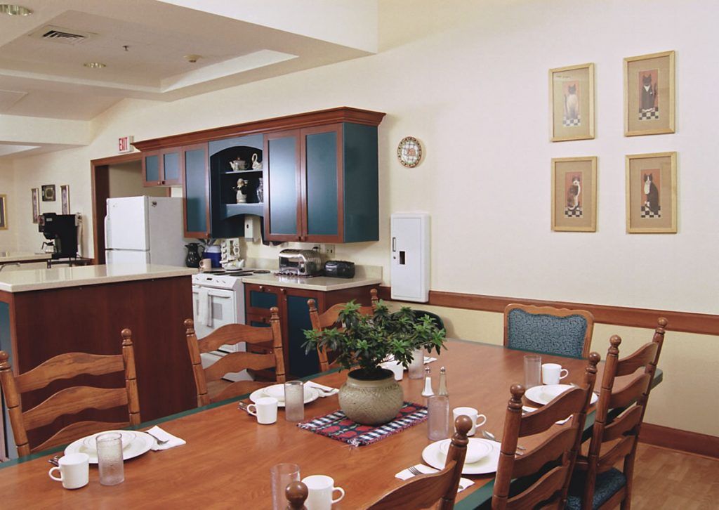 A cozy kitchen and dining area with wooden furniture and a decorative plant centerpiece.