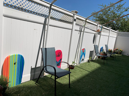 A sunny outdoor space featuring decorated walls and empty chairs, perfect for relaxation.