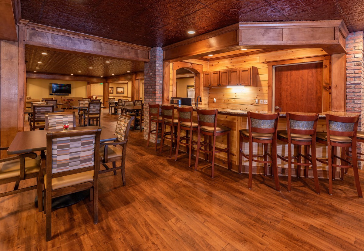 A cozy restaurant interior featuring a wooden bar and seating area.