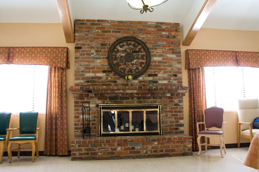 A cozy living room featuring a rustic brick fireplace and a stylish round clock.