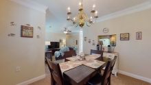 A cozy open-plan dining and living area featuring a chandelier and elegant furniture.