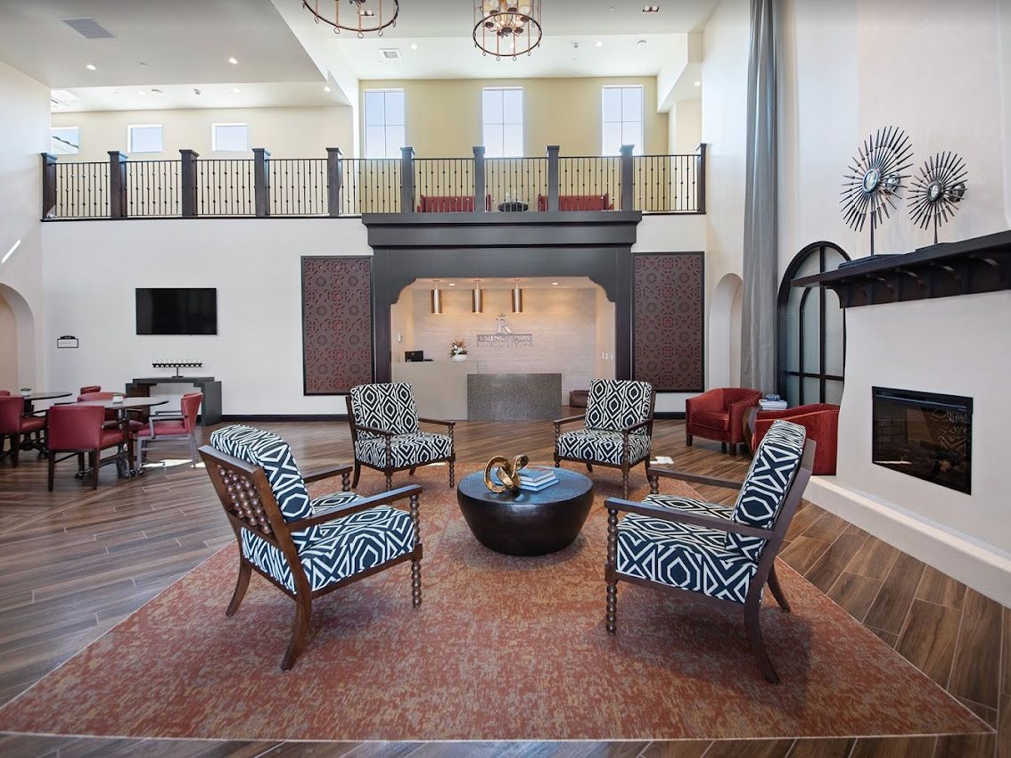 A modern living room with high ceilings, featuring a central seating area and stylish decor.