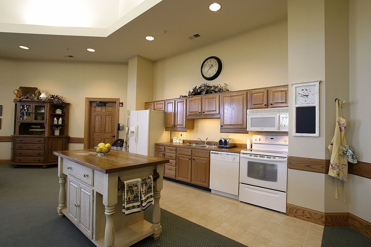 A modern kitchen with wood cabinets, an island counter, and various appliances.
