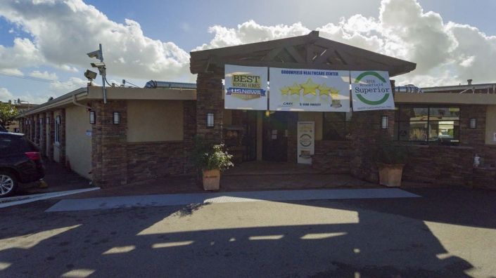 A building entrance with banners and signage under a clear sky.