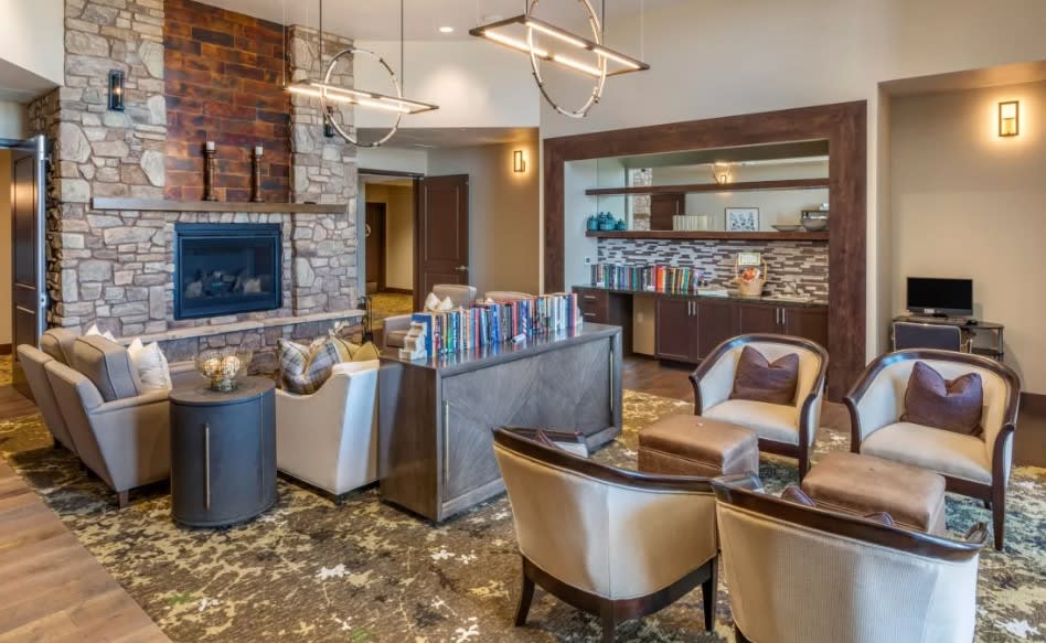 A modern living room with a cozy seating arrangement, fireplace, and contemporary lighting.