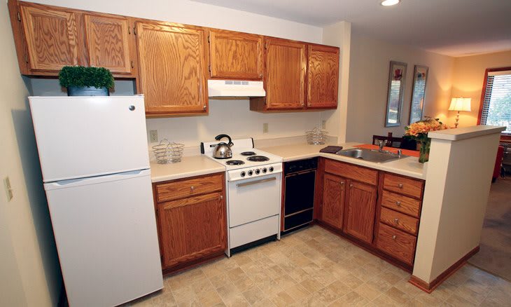 A cozy kitchen with wooden cabinets and essential appliances including a stove and refrigerator.