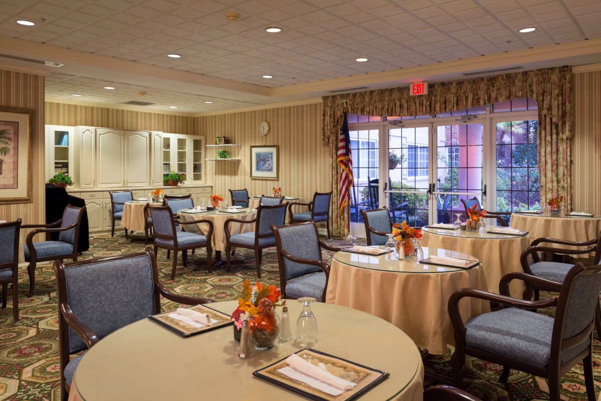 A elegantly decorated dining area with round tables and chairs set for a restaurant or event.
