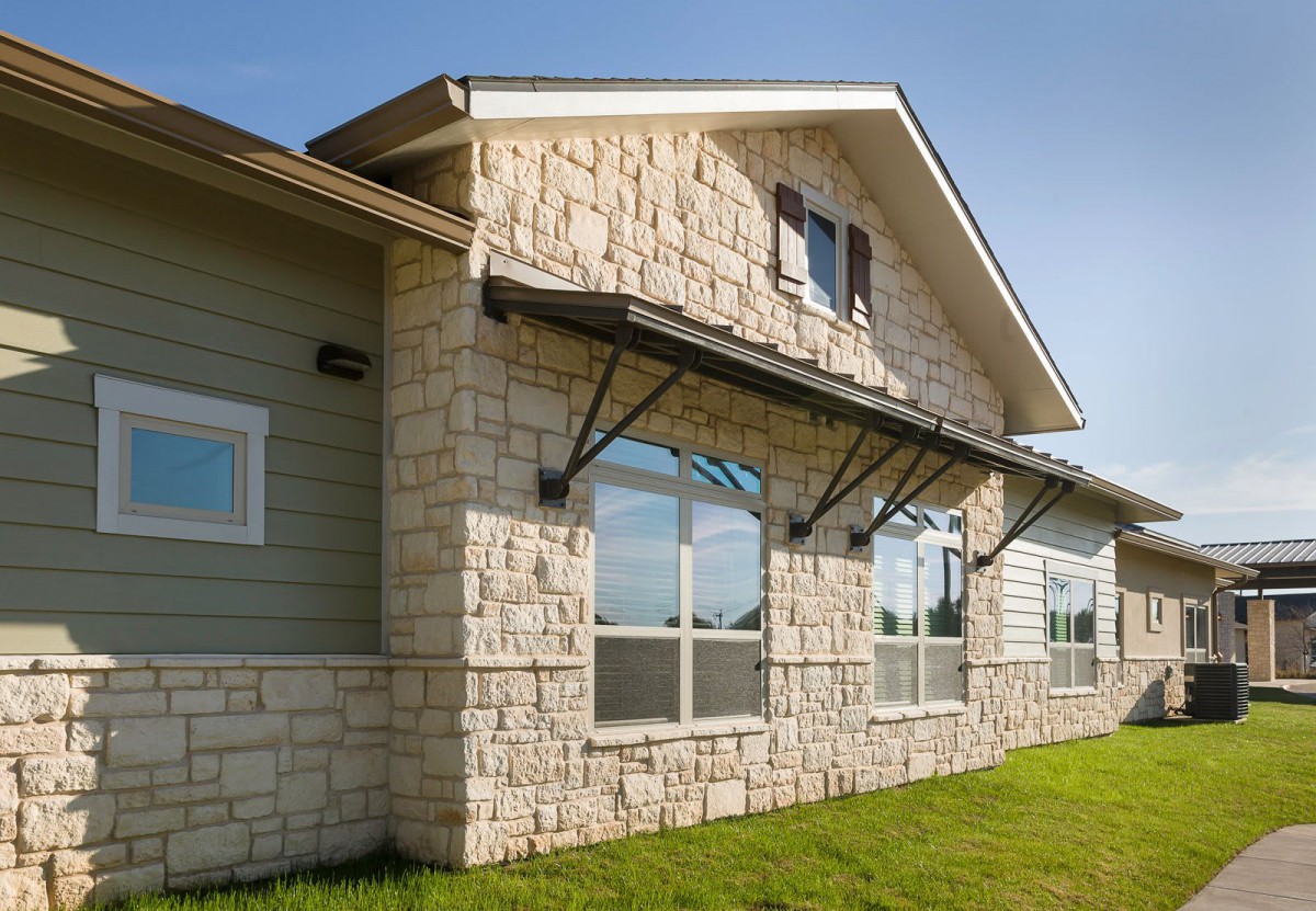 Modern house with a stone facade and large windows.