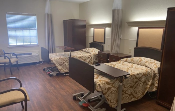 A shared hospital room with two beds and medical equipment.